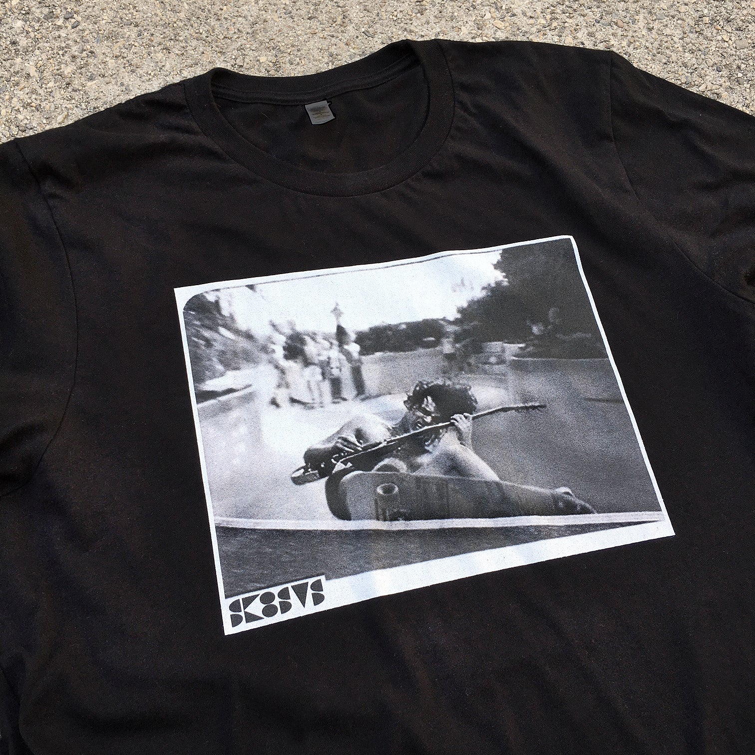black skateboard tee shirt with a pool skater grinding while playing rock guitar acdc angus young streetwear custom diy
